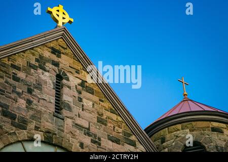 Varie croci tradizionali in cima a una casa di pietra di culto. Foto Stock