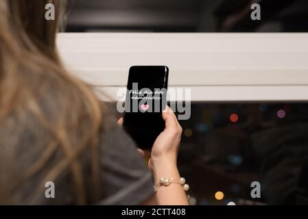 Donna brasiliana appeso un cellulare scritto 'Feliz dia dos Namorados' (Buon San Valentino in portoghese) Foto Stock