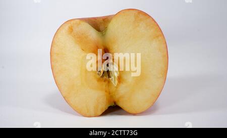 Metà della pelle croccante di mela rossa di miele su bianco sfondo Foto Stock