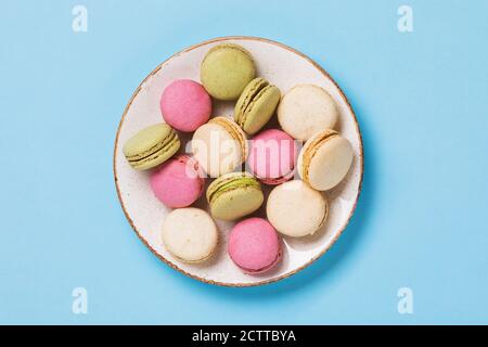 Piatto completo di vari macaron su sfondo blu, vista dall'alto Foto Stock