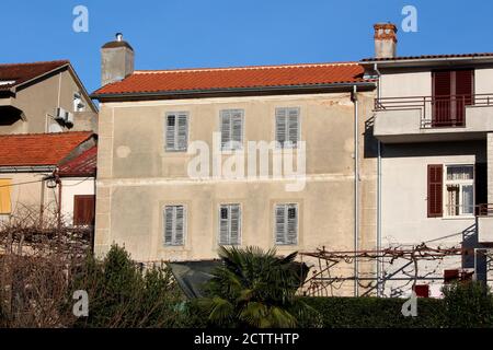 Parzialmente ristrutturato grande vecchia casa familiare con vecchio dilapidaidated facciata e persiane chiuse in legno fessurato e nuove tegole con nuovo lucido Foto Stock