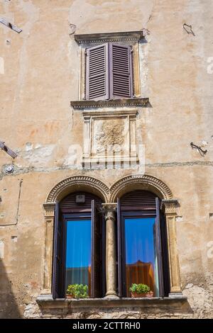 Casa vecchia facciata, grandi finestre, persiane aperte. nel famoso villaggio turistico di Garda, Italia Foto Stock