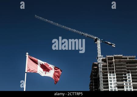 Bandiera canadese con costruzione di appartamenti in costruzione in background, economia canadese e mercato immobiliare. Foto Stock