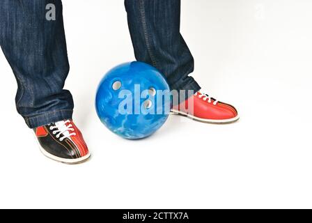 Piedi maschi in scarpe da bowling e palla da bowling su bianco sfondo Foto Stock