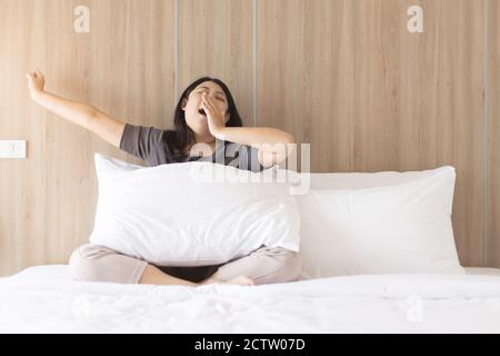 La donna pigra gridò e si allungò dopo essersi svegliata al mattino. Foto Stock