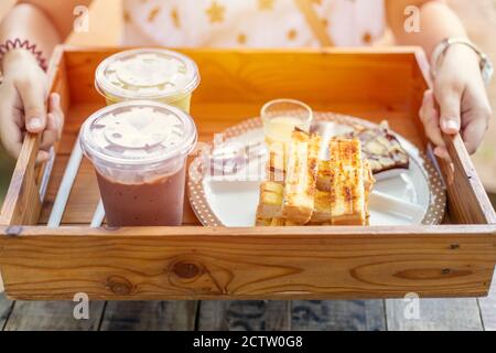 Servizio a mano di pane burro toast e ghiaccio cioccolato dolce cibo al Thailandia caffè. Foto Stock