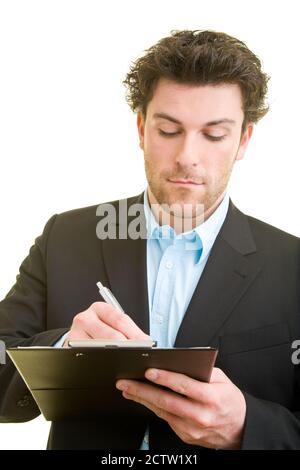 Il giovane uomo in tuta prende appunti su una clipboard Foto Stock