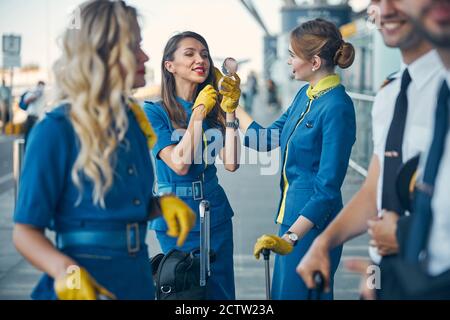 Affascinanti hostess e piloti in piedi sulla strada Foto Stock
