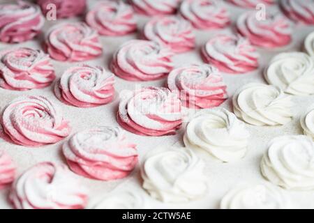 Il processo di produzione del marshmallow zephyr alla cucina della pasticceria. Marshmallow rosa fatto in casa in zucchero in polvere. Fotografia alimentare. Zephyr spolverato con pow Foto Stock