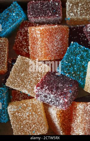 Caramelle di marmellata multicolore fatte in casa in zucchero su sfondo scuro. Caramelle di gelatina di frutta. Caramelle alla frutta. Fagiolo di gelatina. Assortimento di frutta colorata j Foto Stock