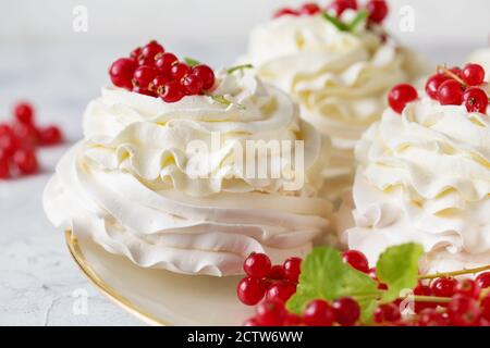 Torte Pavlova con panna e frutti di bosco estivi freschi. Primo piano di dessert Pavlova con frutta di bosco e menta. Macro fotografia alimentare Foto Stock