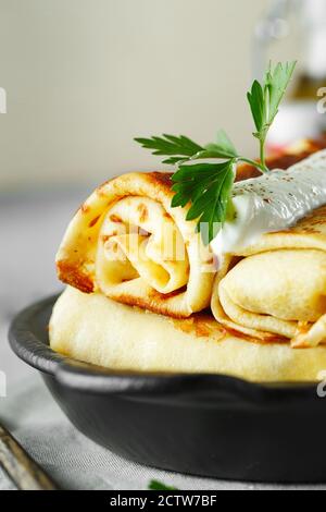 Frittelle sottili con ripieni. Gustose frittelle ripiene con garofano di cavolo. Fritte russe Pancakes ripiene Blintzes con cavolo. Fotografia di cibo Foto Stock