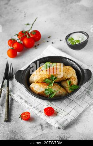 Deliziosi polpette di manzo o di pollo alla griglia. Polpettine di carne o pesce sulla padella servita con prezzemolo e pomodori. Fotografia alimentare. Foto Stock