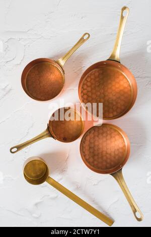 Utensili in rame su sfondo bianco. Pentole in rame vintage - cocotte, crema e accessori per caffè. Foto Stock