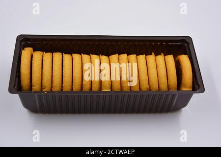 Deliziosi biscotti appena sfornati croccanti con noci e ripieno di cioccolato all'interno. Biscotti a forma di mela con ripieno marrone su un bianco opaco. Foto Stock