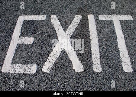 La parola USCITA è apinted sul marciapiede di un parcheggio. Foto Stock