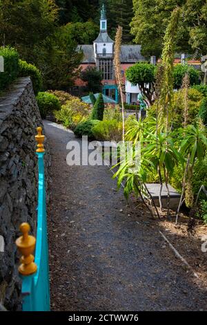 Un percorso con una vista sul bellissimo edificio del Municipio nel villaggio di Portmeirion nel Galles del Nord, Regno Unito. Foto Stock