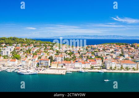 Vista aerea del lungomare nella città di Lussino sull'isola di Lussino, costa adriatica in Croazia, monte Velebit sullo sfondo Foto Stock