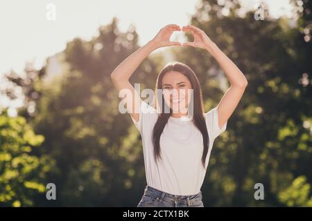 Ritratto di lei bella-aspetto attraente affascinante allegro attento Affettuosa ragazza godendo buon San Valentino aria fresca mostrando cuore Foto Stock