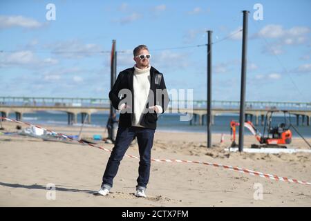 Satirist Cold War Steve, aka Christopher Spencer, a Boscombe Beach, Bournemouth, prima dell'installazione del suo lavoro, un windbreak curvo di 25 metri che raffigura una scena di Bournemouth Beach, come parte del Bournemouth Arts dal Sea Festival 2020. Foto Stock