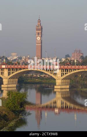 India, Uttar Pradesh, Lucknow, ponte sul fiume Gomti con Torre dell'Orologio in lontananza Foto Stock