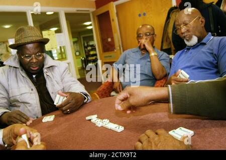 Gli anziani giocano a domino in un centro multiculturale; Bradford Foto Stock