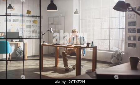 Frustrato e stanco, Young Creative Designer lavora su laptop alla sua scrivania. Sta provando rabbia e insoddisfazione, mostrando Facepalm. Foto Stock