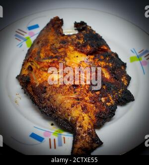 Pesce intero su piatto isolato: Carne alla griglia grigliata di pesce cucinata in piatto con vista ravvicinata. Pesce alla griglia su sfondo bianco Foto Stock