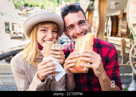 Bella giovane coppia seduta in un bar ristorante e mangiare un sandwich Foto Stock