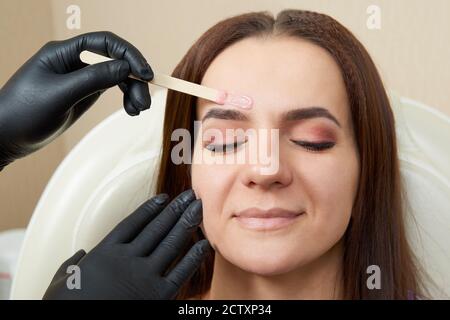 Bella ragazza ottenere ceretta di fronte in salone di bellezza Foto Stock