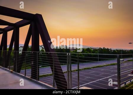 alba attraverso il cielo pieno di fumo su Saddleback Mountain nella contea di Orange da un ponte pedonale su una strada principale a Irvine, California, Stati Uniti Foto Stock