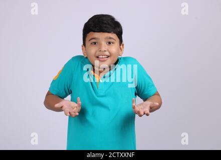 Un ragazzo indiano senza indizi e perplesso con le braccia, che le si strinse sulle spalle, dicendo: Chi si preoccupa, e così cosa, Non lo so. Emozione umana negativa Foto Stock