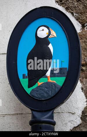 Un'illustrazione Puffin su un cartello nella città di Beaumaris in Galles. Beaumaris è il luogo da cui partono le gite in barca per l'isola di Puffin. Foto Stock