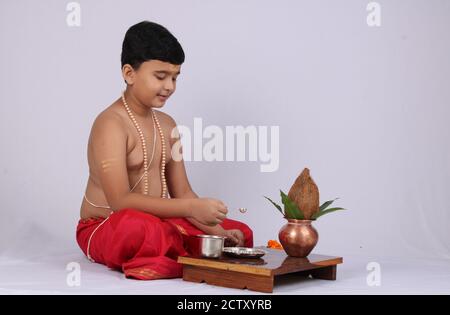 Giovane ragazzo indiano che offre Sandhyavandanm - saluto alla Dea durante la sera. Un rituale religioso obbligatorio eseguito da Dvija Hindus. Foto Stock