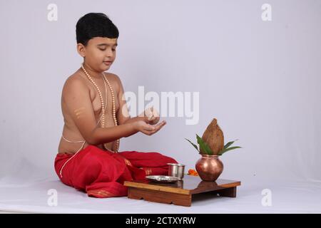 Giovane ragazzo indiano che offre Sandhyavandanm - saluto alla Dea durante la sera. Un rituale religioso obbligatorio eseguito da Dvija Hindus. Foto Stock