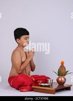 Giovane ragazzo indiano che offre Sandhyavandanm - saluto alla Dea durante la sera. Un rituale religioso obbligatorio eseguito da Dvija Hindus. Foto Stock