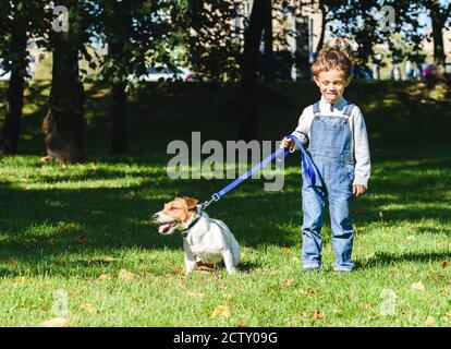 Divertente ragazzo ragazzo che copia e stuzzicante cane con lingua fuori Foto Stock