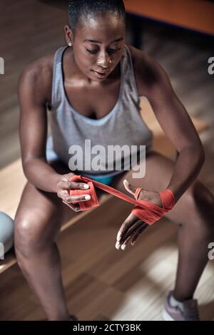 Una giovane boxer femminile in un armadietto che si concentra e. preparandosi per una lotta Foto Stock