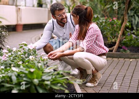 Giovane coppia che gode di splendidi fiori in un giardino botanico Foto Stock