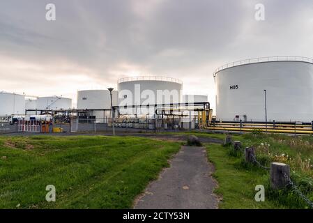 Serbatoi di stoccaggio dell'olio in un'area industriale al tramonto Foto Stock