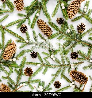 Texture fatta di Natale con rami di abete, coni di pino su sfondo bianco. Disposizione piatta, concetto di decorazione per le vacanze con vista dall'alto. Foto Stock