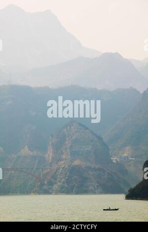 Barca nel fiume con montagne foggy sullo sfondo, Xiling Gorge, Yangtze fiume, Provincia di Hubei, Cina Foto Stock