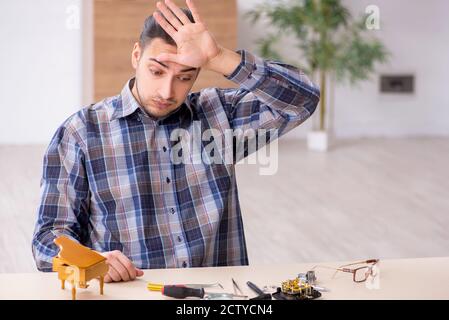 Giovane orologiaio che lavora in officina Foto Stock