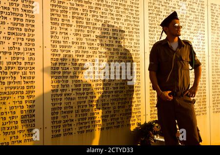 Soldato dell'esercito che si trova di fronte al Muro dei nomi memoriale ai soldati caduti, Armored Corps Memorial, Latrun, Ayalon Valley, Shefelah, Israele Foto Stock