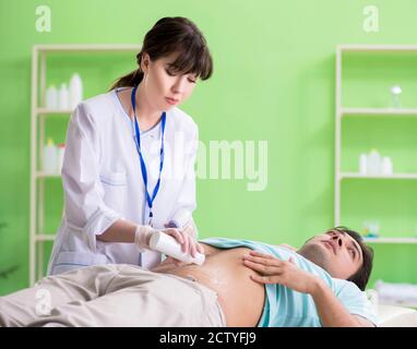 Il giovane uomo visitando radiologyst per procedura di ultrasuoni Foto Stock