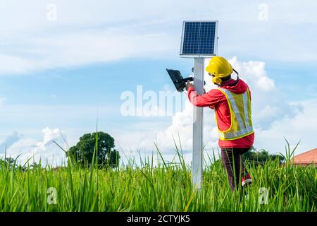Tecnico asiatico installare la manutenzione dei pannelli solari, palo di illuminazione esterna con piccola energia solare pannello da themself è nuova tecnologia e ene Foto Stock