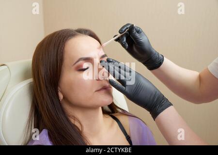 Bella ragazza ottenere ceretta di fronte in salone di bellezza Foto Stock