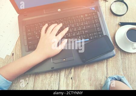donna che lavora in computer e telefono e caffè su legno tabella Foto Stock