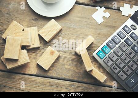 calcolatrice e blocchi di legno sulla scrivania dell'ufficio Foto Stock