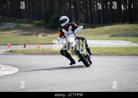 Moto pratica inclinandosi in una curva veloce in pista. Foto Stock